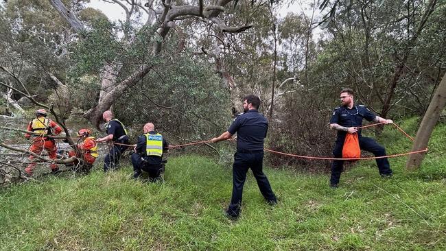 Emergency workers rescuing a woman from flood waters after heavy rain at the Buchan campground in east Gippsland, located east of Melbourne. (Photo by Handout / VICTORIA POLICE / AFP)