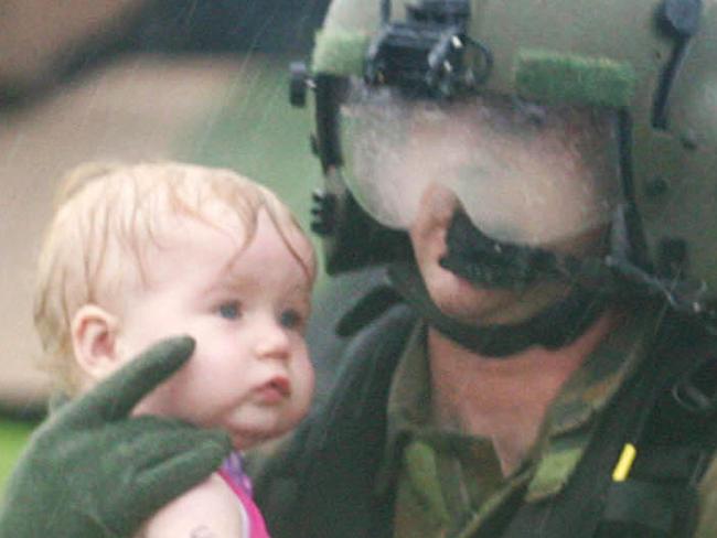 MUST CREDIT: Jack Tran...NOT FOR INTERNET... 11/01/2011 NEWS: MUST CREDIT: Jack Tran...NOT FOR INTERNET... 01/11/2011 NEWS: An Army helicopter crew member carries baby Montana to drier land in Gatton after she was rescued and airlifted from flooded area of Forest Hill, west of Brisbane as torrential rain continues to fall on flood-ravaged Queensland. N12537976 N12537976