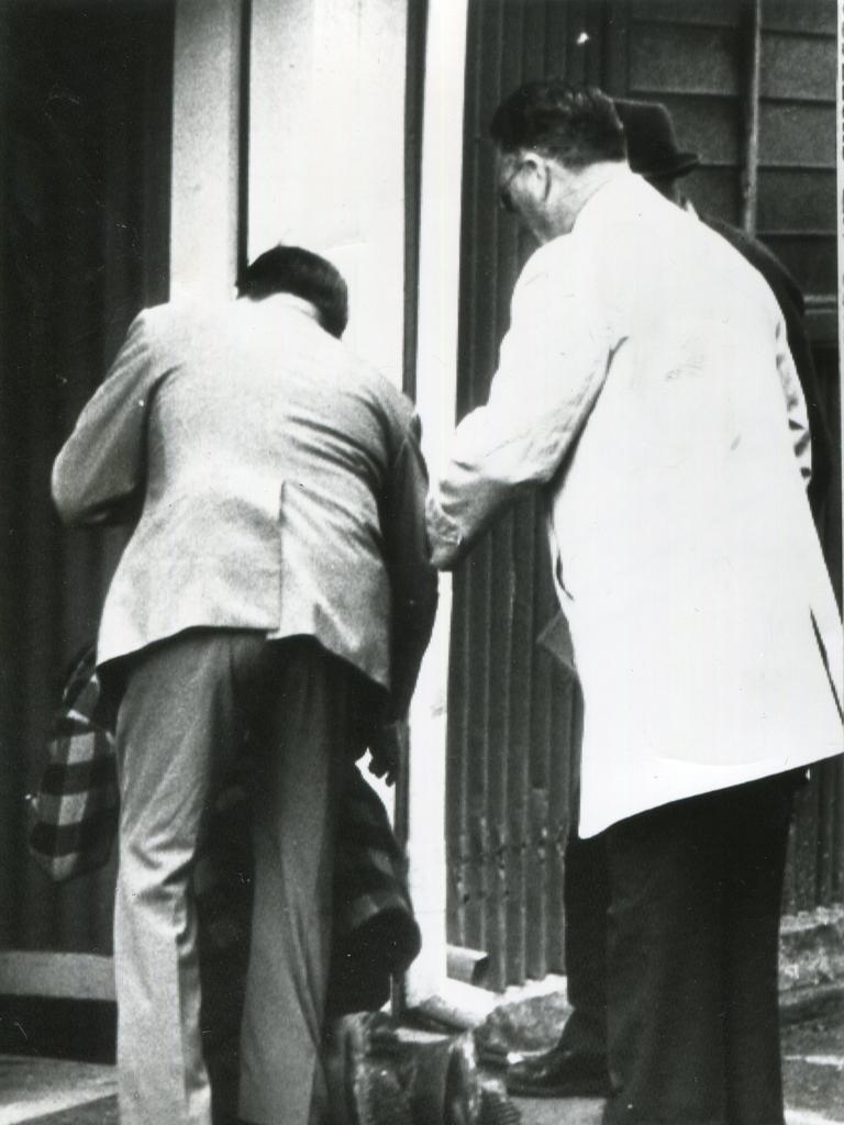 Detective Sergeant John McCall and Inspector C.E Lehmann go to the aid of Leslie Ratcliffe, the father Joanne, as he collapses at Adelaide Oval during the search for his daughter.