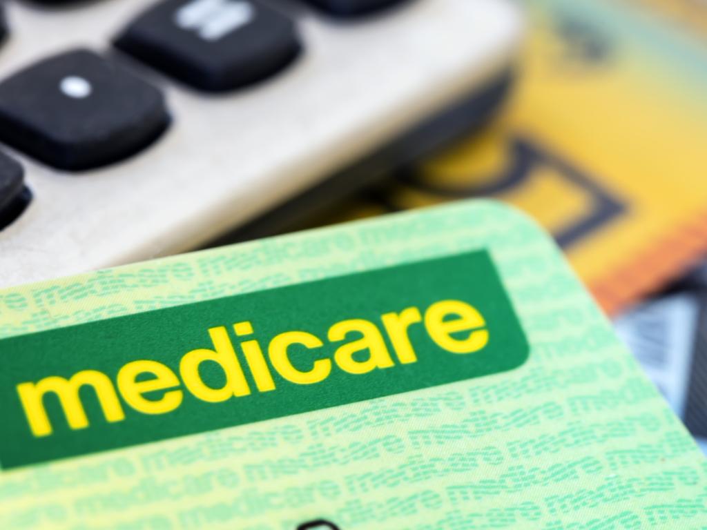 Australian Medicare card with calculator and cash background.