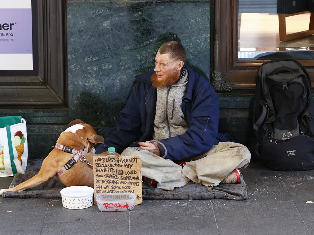 A homeless man begging on George St. Picture: Richard Dobson