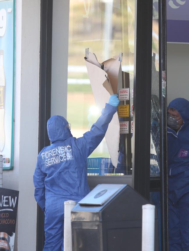 Police and forensic officers at the Caltex station in Queanbeyan. Picture: Kym Smith