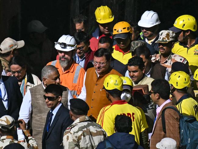 Australian Professor Arnold Dix, (in orange vest) who is heading up the rescue efforts, with officials leaving the tunnel entry. Picture: AFP