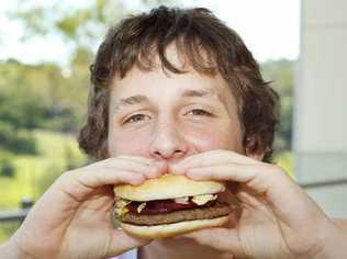 Kyle Grice, 14, of Ipswich tries one of McDonalds McOz Burgers with locally grown beetroot.  . Picture: David Nielsen