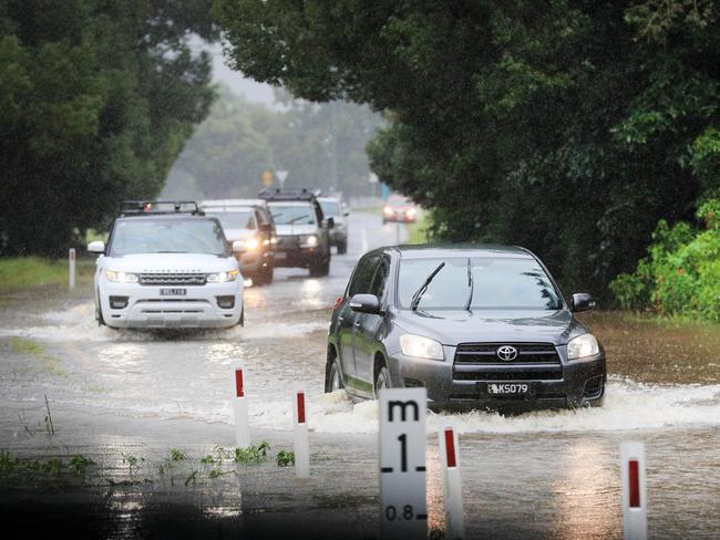 Drivers make their way across Tallebudgera Connection Road, Tallebudgera, at the back of Currumbin Creek after torrential rain over night caused the creek to break its banks. NCA NewsWire / Scott Powick