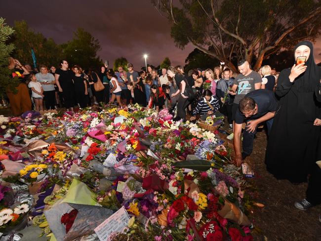 People surround floral tributes to Aiia Maasarwe. Picture: Tony Gough