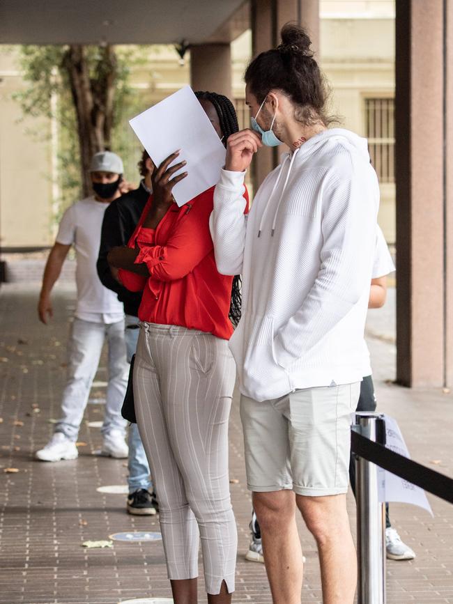 Adhok Yac, with a supporter, conceals her face. Picture: Monique Harmer