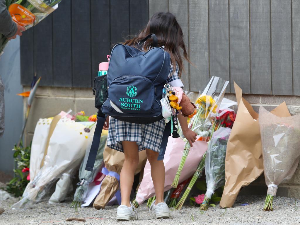 A young student lays flowers at the scene of the tragedy. Picture: David Crosling