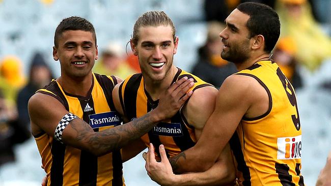 Ryan Schoenmakers (centre) is swamped by Brad Hill (left) and Shaun Burgoyne after booting a goal.