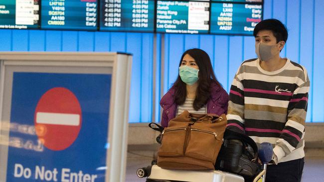 Passengers at an airport wear protective masks to protect against the spread of the Coronavirus. Picture: AFP