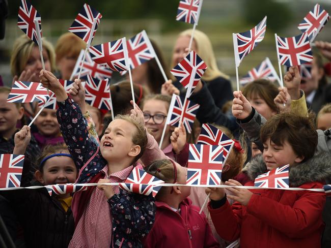 Children wave the Union Jack flag as they await the arrival of Queen Elizabeth II and Meghan, Duchess of Sussex to open the new Mersey Gateway Bridge. Picture: Getty