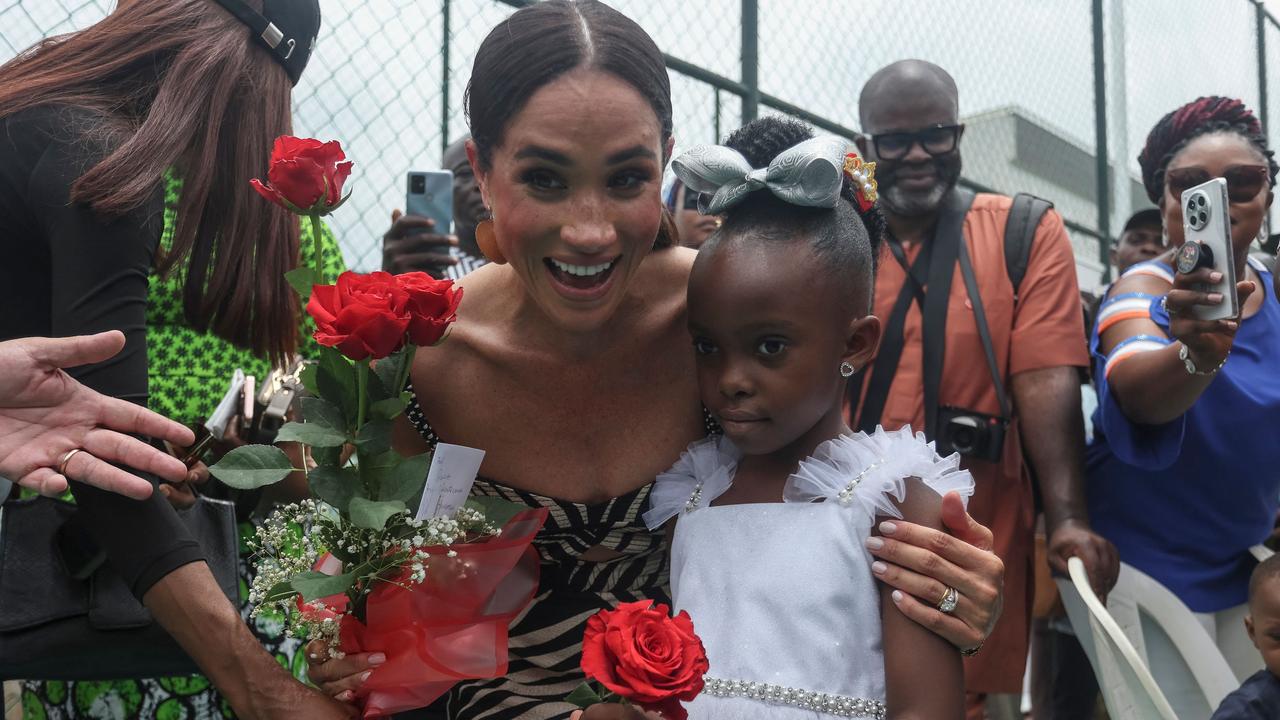 Meghan receives flowers from a young girl. Picture: AFP.