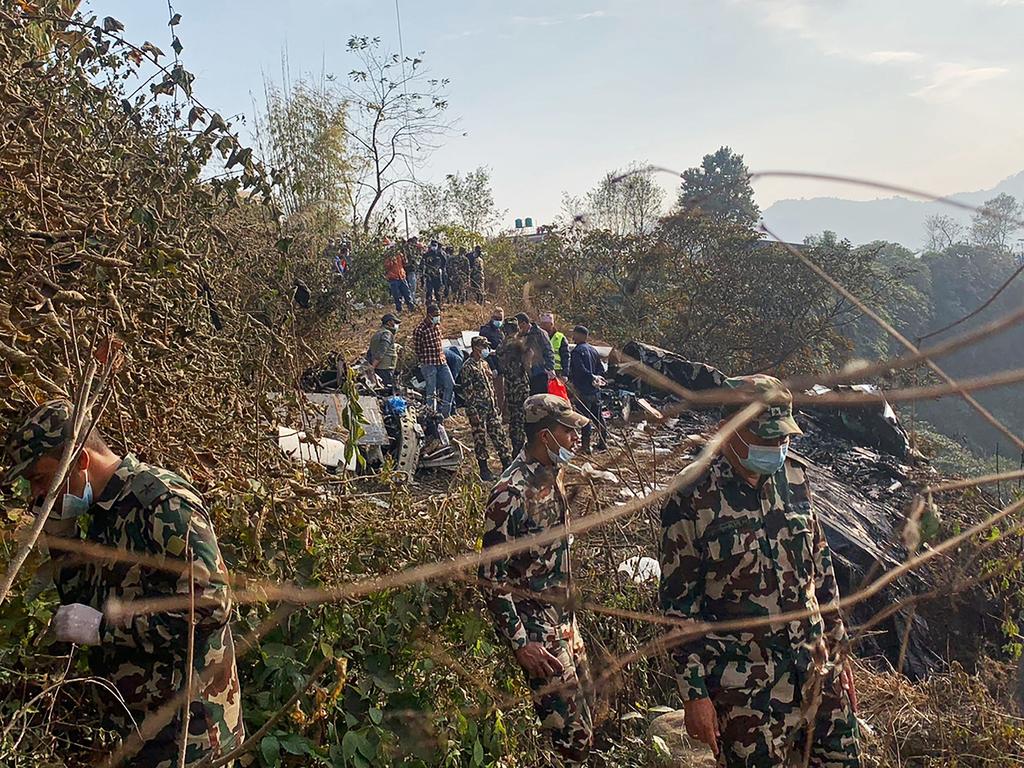 Rescuers gather at the site of a plane crash in Pokhara after a plane with 72 on board in the Himalayan country's deadliest aviation disaster in three decades. Picture: Prakash Mathema / AFP