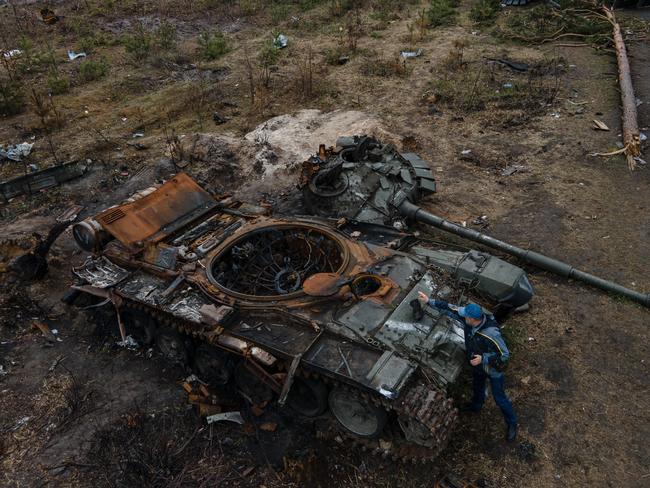 DMYTRIVKA, UKRAINE - APRIL 21: In this aerial image, a man places a boot to take a photo of a destroyed Russian military tank on April 21, 2022 in Dmytrivka, Ukraine. (Photo by Alexey Furman/Getty Images)