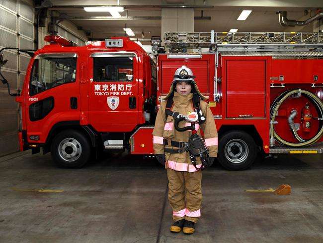 Ran Namise, 24, a firefighter belonging to the command squad, in front of a fire engine at Kojimachi Fire Station in Tokyo. Picture: AFP