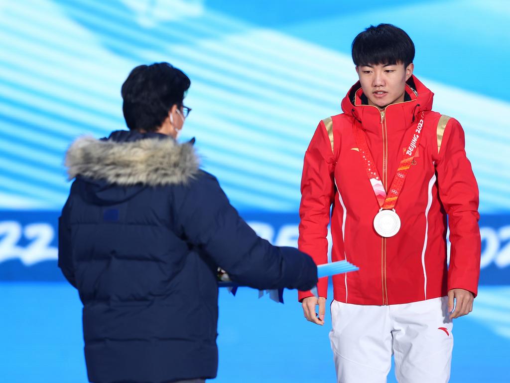 BEIJING, CHINA - FEBRUARY 08: Silver medallist Wenlong Li of Team China receives their medal during the Men's 1000m Speed Skating medal ceremony on Day 4 of the Beijing 2022 Winter Olympic Games at Beijing Medal Plaza on February 08, 2022 in Beijing, China. (Photo by Elsa/Getty Images)