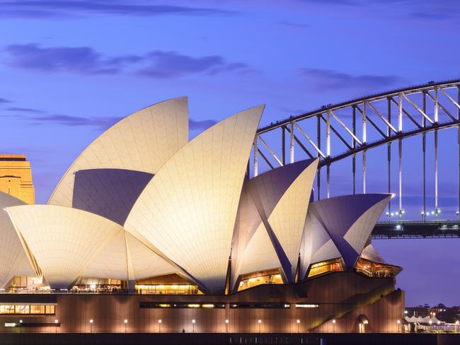 Sydney, Australia - November, 21st 2012; Sydney Opera House and the Harbour Bridge illuminated at dusk. View across Farm Cove, looking west.