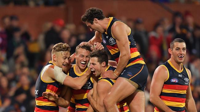 Adelaide players mob Myles Poholke after kicking a goal against the West Coast Eagles. Picture: Daniel Kalisz/Getty Images