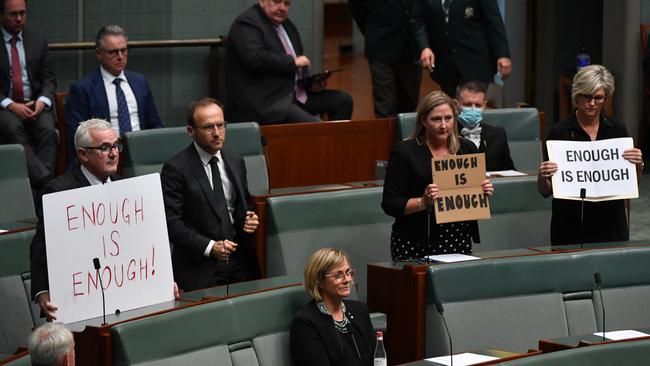 Crossbenchers: Independent Member for Clark Andrew Wilkie, Centre Alliance member for Mayo Rebekha Sharkie and Independent Member for Indi Helen Haines hold up signs reading Enough is Enough during Question Time.