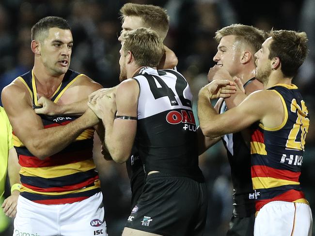 Adelaide captain Taylor Walker battles against Port’ Tom Jonas and Dougal Howard.