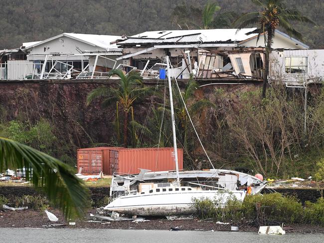 A boat is seen smashed against the bank at Shute Harbour, Airlie Beach. Picture: AAP Image/Dan Peled