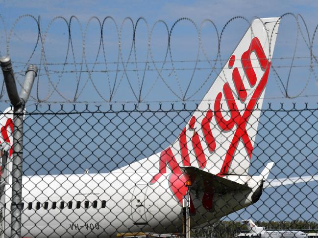 A Virgin Australia aircraft is seen parked at Brisbane Airport in Brisbane, Tuesday, March 31, 2020. Virgin Australia has asked the Federal Government for a $1.4 billion loan to help it through the coronavirus (COVID-19) crisis. (AAP Image/Darren England) NO ARCHIVING