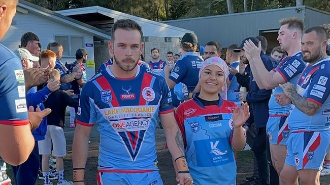 Dora Creek Swampies player Kendyll Fahey leading the team out with Imohgen Alo at Dora Creek Workers Club Oval on July 28, 2024. The club put on a fundraising day for the 10-year-old, who is receiving treatment for T-cell lymphoma. Picture: supplied