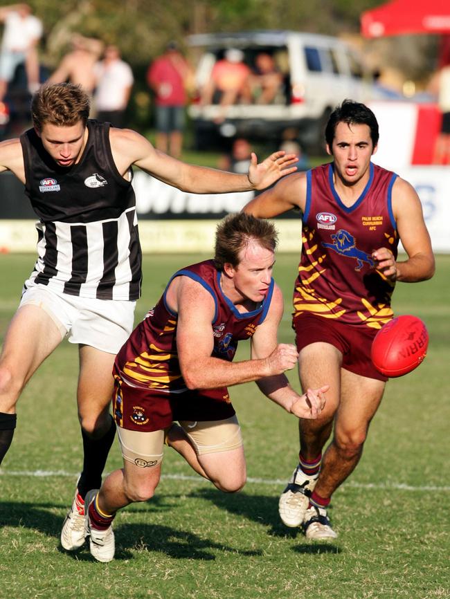 AFL Queensland second division Grand Final match between Palm Beach Currumbin Lions and Western Magpies, at Merrimac Oval, Broadbeach. Palm Beach Currumbin's Mikal Bloom offloads the ball.
