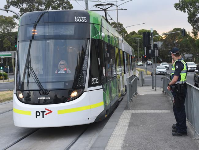 Police officers man tram stop 61 on Plenty Rd in Bundoora. Picture: Tony Gough