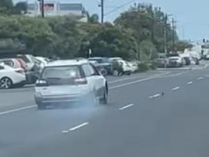 The early model white Subaru driving on two blown tyres before crashing into a median divider on Sheridan St on Tuesday afternoon. Picture: Amu SyluMay