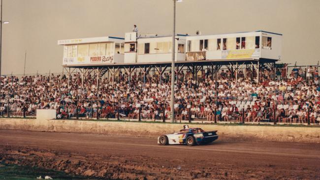 Historic photo of a car racing past the crowd at the Archerfield Speedway. Picture: Brisbane John Oxley Library, State Library of Queensland