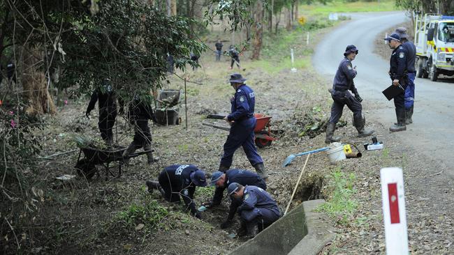 Police dig in a muddy culvert on the side of a bush creek, near Kendall, in the search for William Tyrrell's remains.