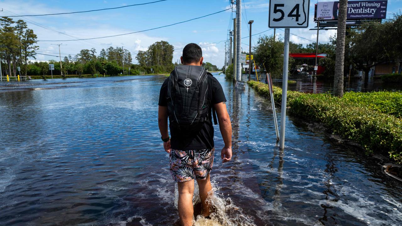 People walk in water as roads and businesses are flooded. Picture: Spencer Platt / Getty Images North America / Getty Images via AFP