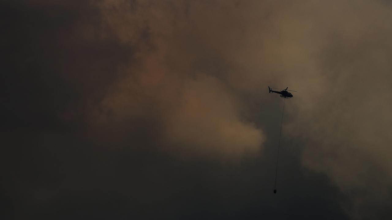 Lachlan Fire: A fire fighting helicopter picks up water near the bush fire at Lachlan. Picture: LUKE BOWDEN