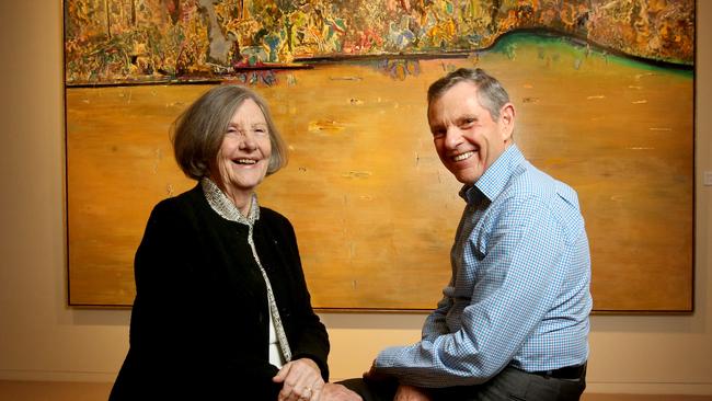 Lyn Williams with Philip Bacon from Philip Bacon Galleries, posing in front of the painting Forest Pond by Fred Williams, 1974 which sold for nearly $3m in 2018. Picture: AAP