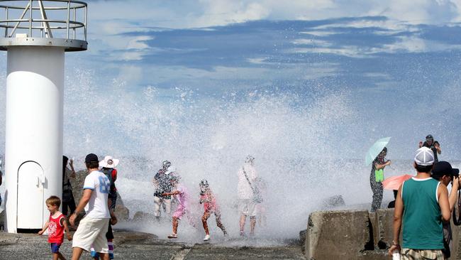 Fun at The Spit when tourists were surprised at the Southport Seaway after a rogue wave crashed over the rock wall.