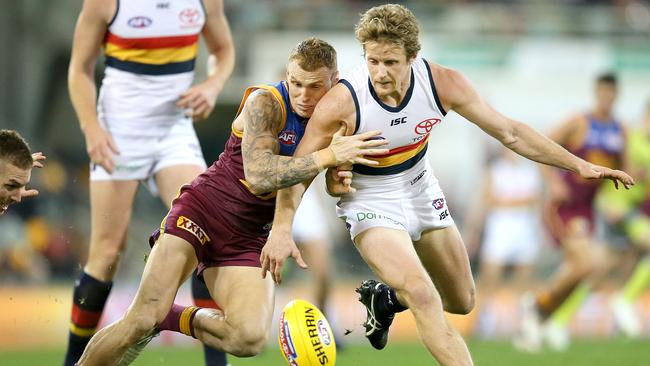 Rory Sloane gets set to pounce on the ball under pressure from Mitch Robinson from Brisbane on Saturday night. Picture: AAP Image/Jono Searle