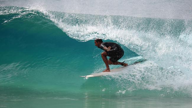 A surfer tucks into a barrel at Duranbah Beach. Picture: David Clark