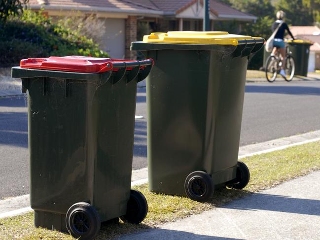 Two rubbish bins in Australia. Red lid is rubbish, yellow lid is recycling.