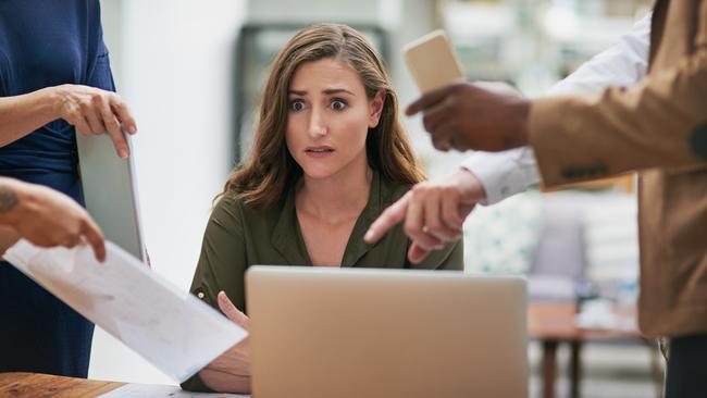 CAREERS: Shot of a young businesswoman looking anxious in a demanding office environment.