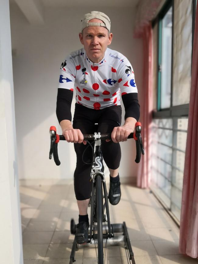 Housebound expat Dr Simon Carter, riding his bike on a roller inside his 20th floor apartment in Wuhan. Supplied: Simon Carter