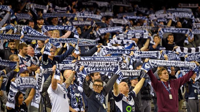 Victory fans wave their scarfs during the Melbourne derby.