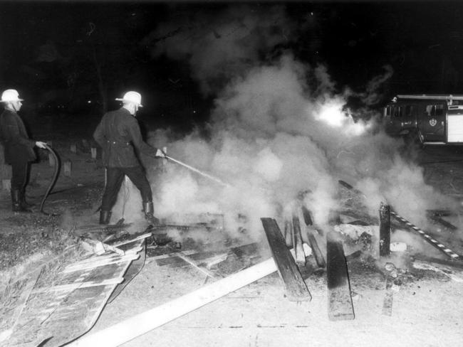 Fire brigade officers douse flames at Cumberland Oval caused by over exuberant fans after Parramatta defeated Newtown at SCG in Sydney in 1981 rugby league grand final.