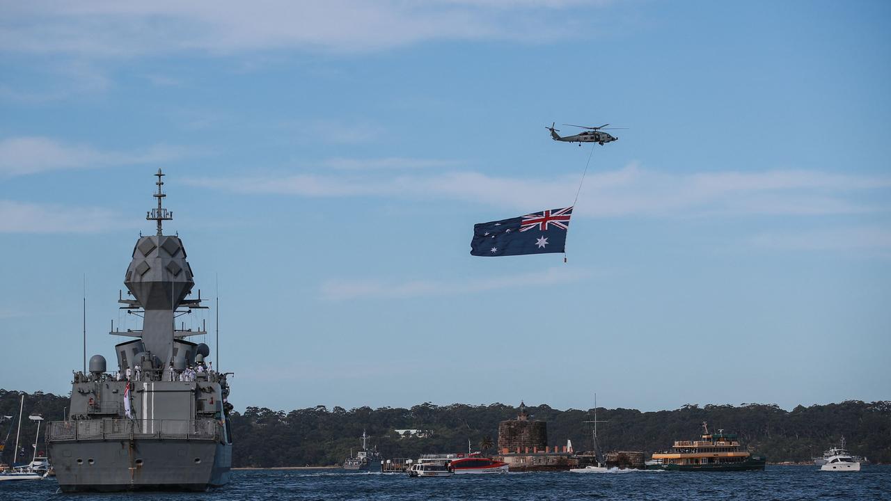 A helicopter flew an Australian national flag over Sydney Harbour. Picture: Roni Bintang / POOL / AFP