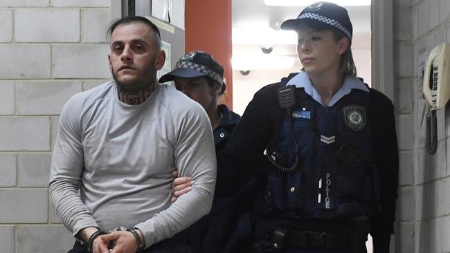 Yusuf Nazlioglu pictured in handcuffs at Kogarah Police Station. Picture: Gordon McComiskie