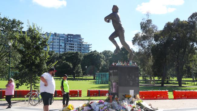 People continue to place flowers and other items at the Shane Warne statue at the MCG. Picture: NCA NewsWire / David Crosling.