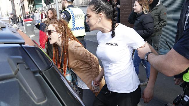 The mother of Jari Wise, Faith Tkalac (red dreadlocks) alongside family and friends yell and at and chase down Jari's former girlfriend, Melissa Oates as she leaves Hobart Magistrates Court under police escort after her court hearing was adjourned. Picture: Zak Simmonds