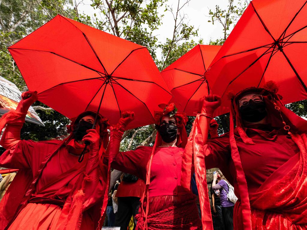 ‘The Red Brigade’ are a regular feature of climate protests in their striking red cloaks and silent form of protest. Picture: NCA NewsWire / James Gourley