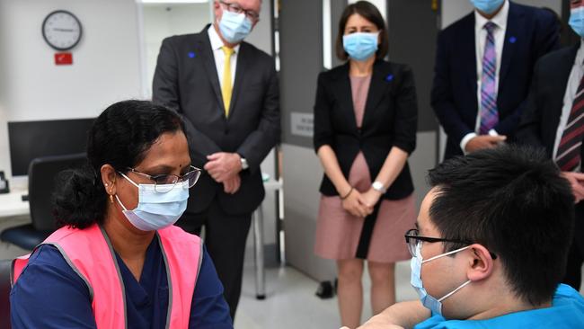 Gladys Berejiklian and Brad Hazzard look on as NSW Health worker Andrew Santoso receives his COVID-19 vaccination at the Westmead Hospital.