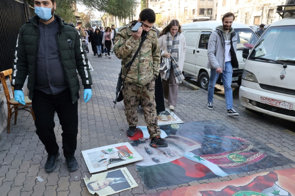 Syrian step on portraits of toppled president Bashar al-Assad in Damascus